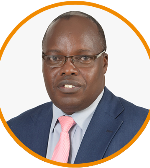 Headshot photograph — man in navy suit, pink tie, glasses, white background, orange circular frame