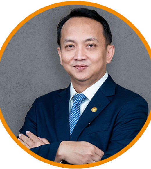 Formal portrait, man in navy suit and striped tie, arms crossed, gray background, orange border